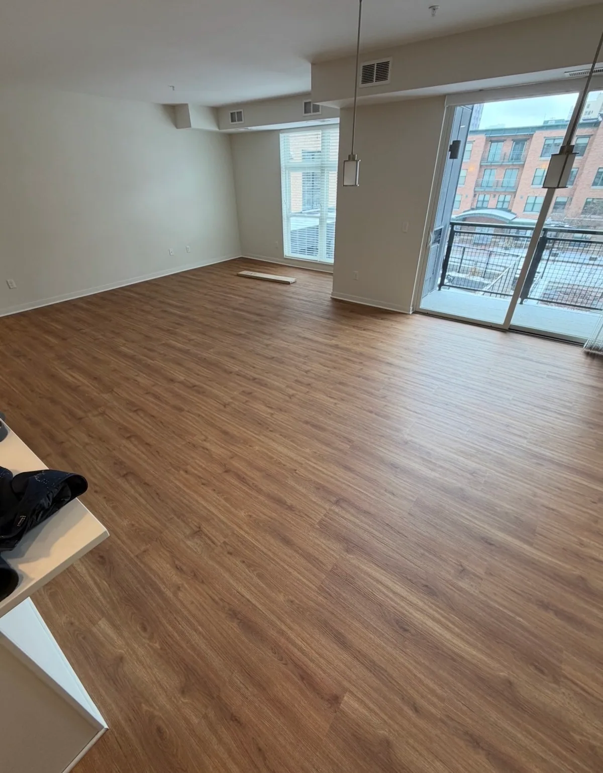 Plank flooring across an open room with large windows