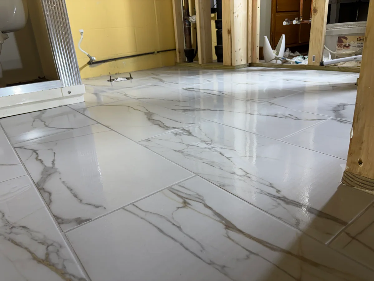 Light floor tile with gray veining in a room under renovation